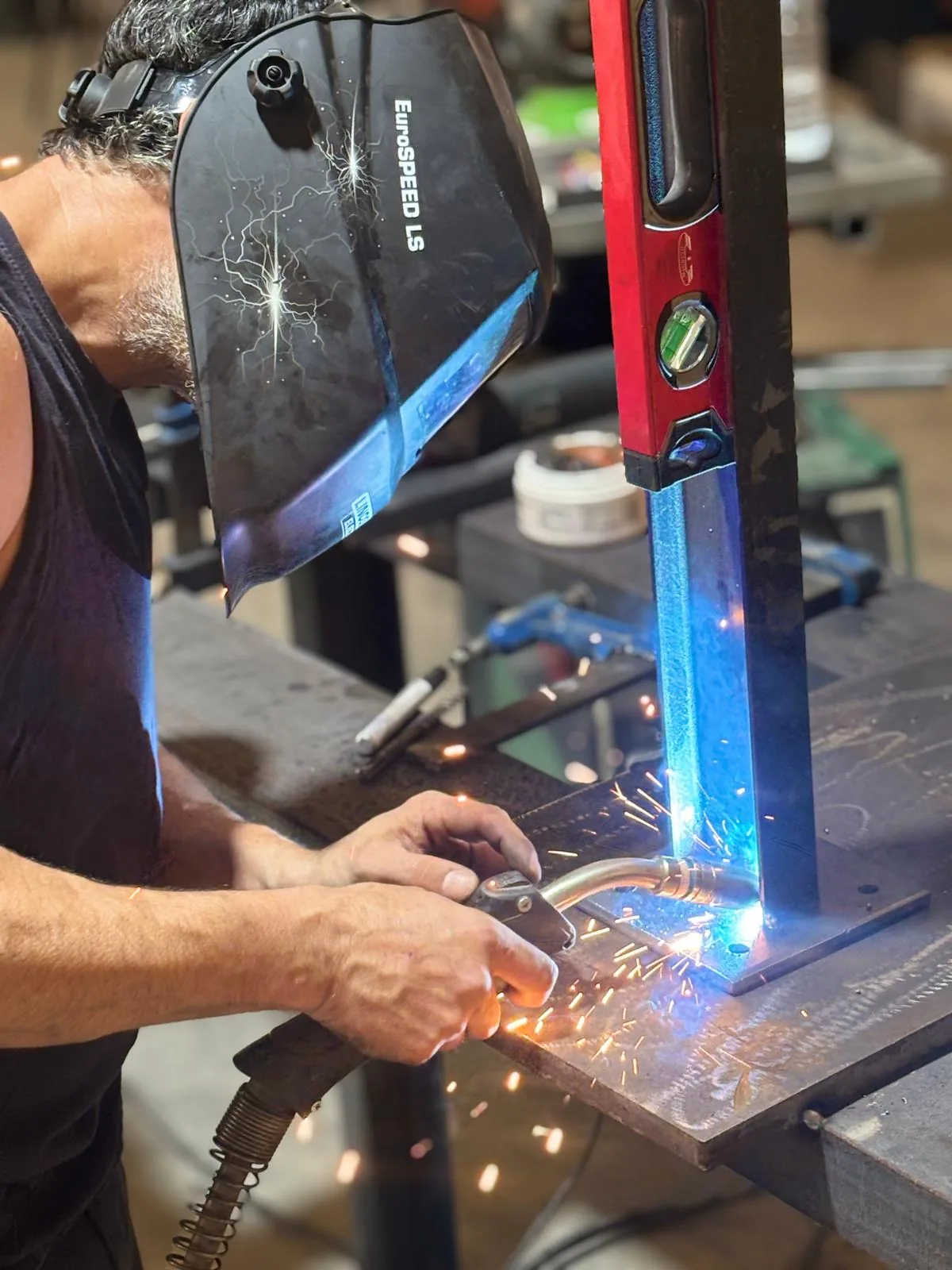 Soldador trabajando con máscara protectora, soldadura de precisión en el taller de Albacete