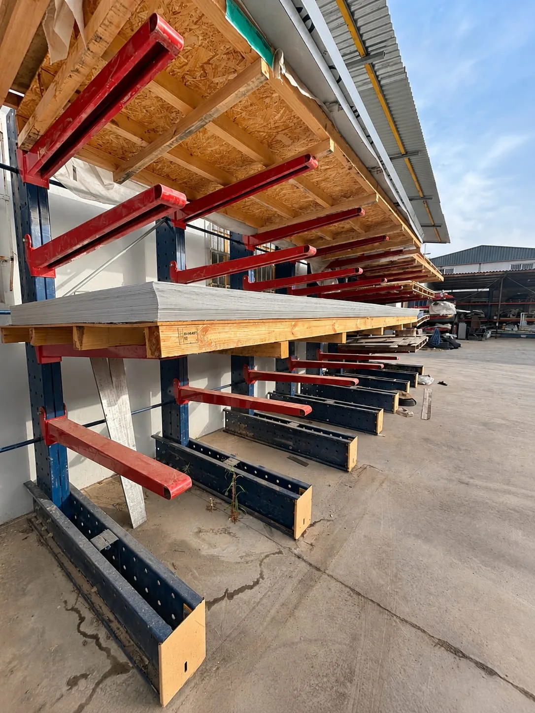 Estanterías cantilever con planchas de material almacenadas en el exterior del taller de Valencia